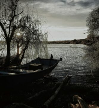 a boat sitting on the shore of a lake